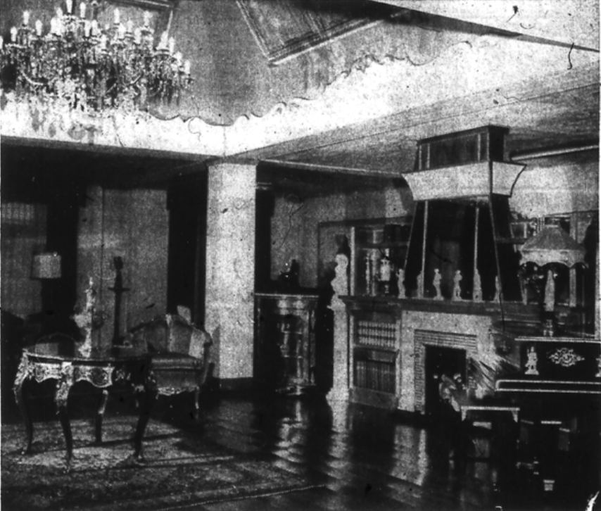 Newspaper image: On either side of the fireplace is a Russian samovar, from Lefkowsky's home in Russia. One is of silver and the other of brass. On the piano is a Chinese jade lamp which is more than 175 years old. At the left of the fireplace is a Boulle corner cabinet of the same period as the table at the left. Both are from the collection of Countess Rucellai of Florance, Italy. The rug is an antique Kermanshah; and on the table is a Russian silver flower vase made in the Royal art-silver shop of Alexander I, (1800-1825). The imperial coat of arms on the vase is inlaid with enamel. The large center chandelier and four sconces in the room-epoch 1765 - are Baccarat crystals and bronze. The group hung in the large salon of the palace of Trabia, in Palermo. 